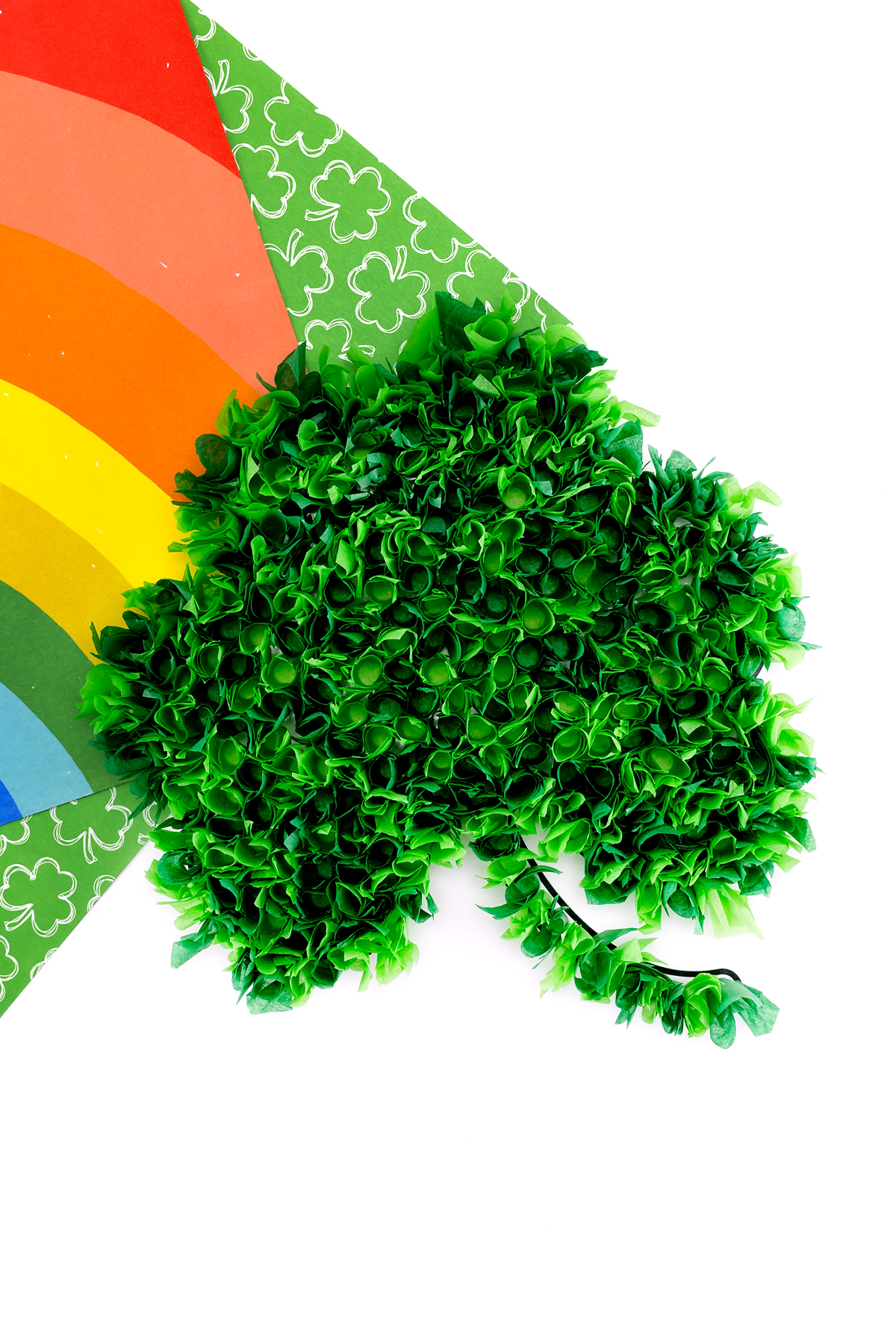 Finished tissue paper shamrock craft for kids on a table. 