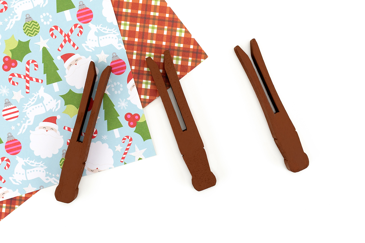 Wooden clothespins are being lightly sanded for a clothespin reindeer ornament craft.