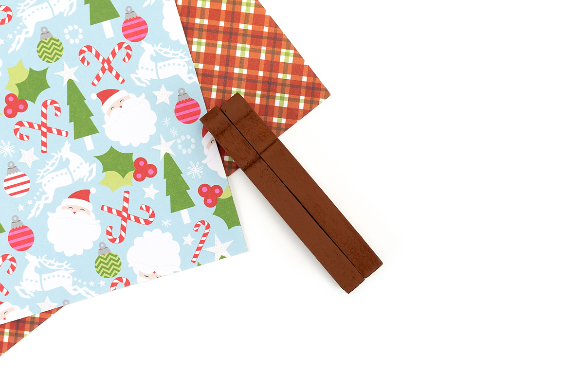 Two brown wooden clothespins are glued side by side to form the body of a DIY reindeer ornament.