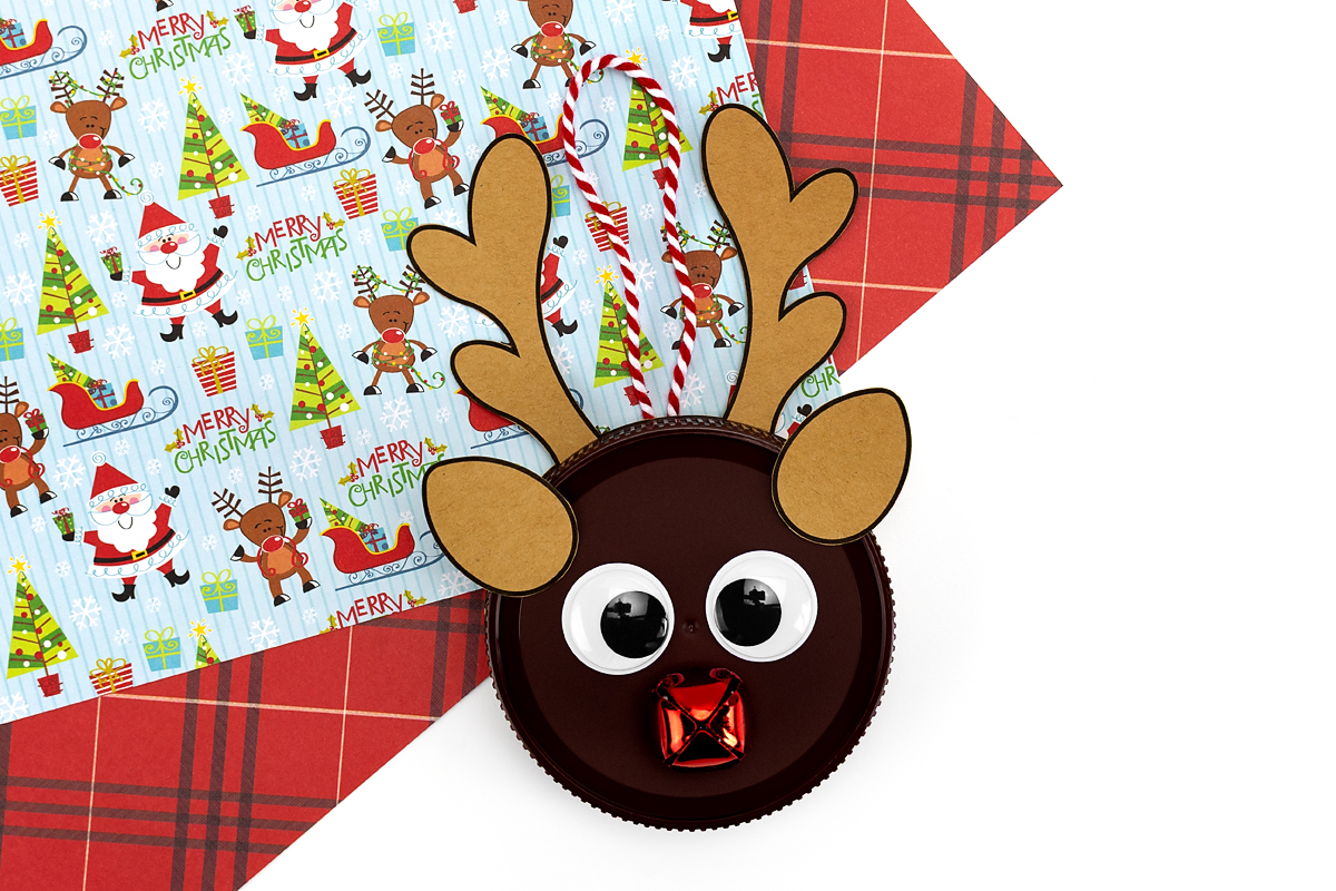 Finished reindeer face with googly eyes, a jingle bell nose, and a loop of string attached for hanging.