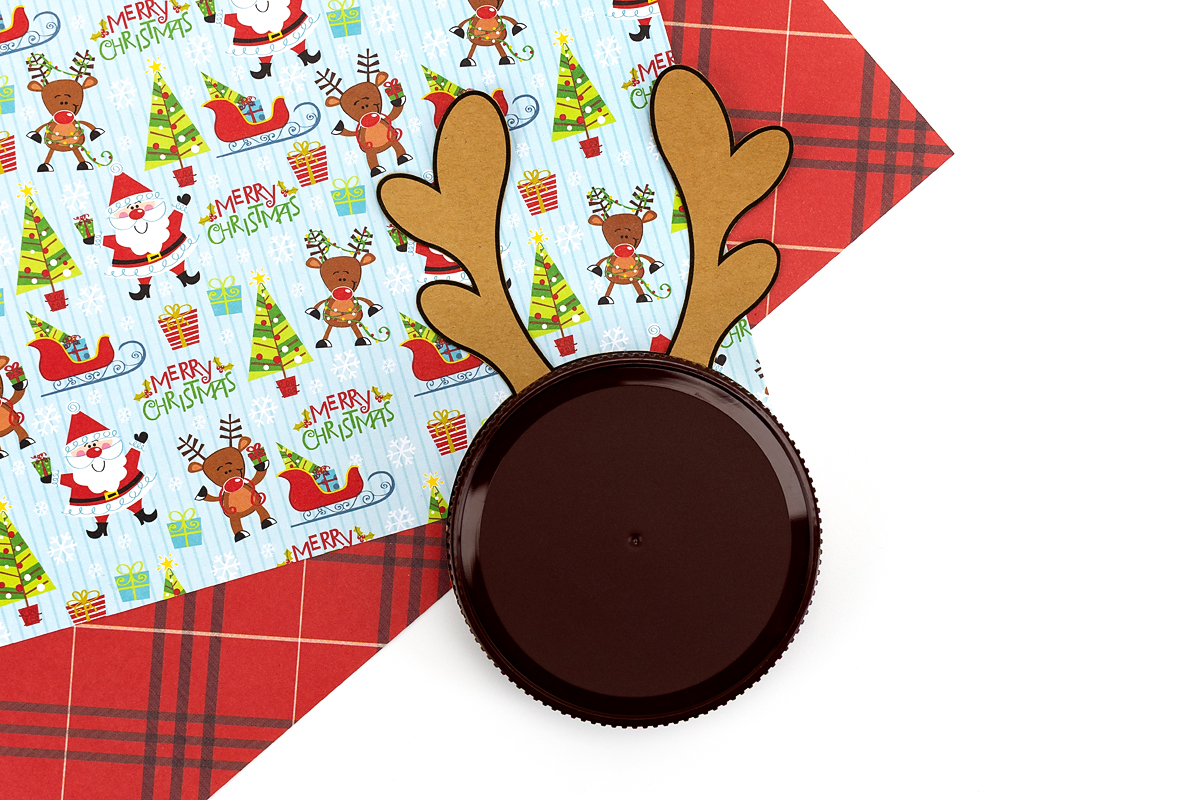 ar lid being glued onto the round paper circle of the reindeer printable.