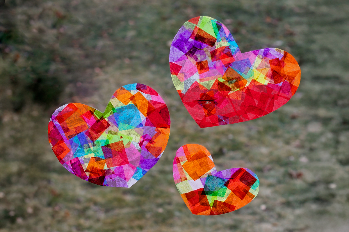 Three finished heart suncatchers hanging in a window.