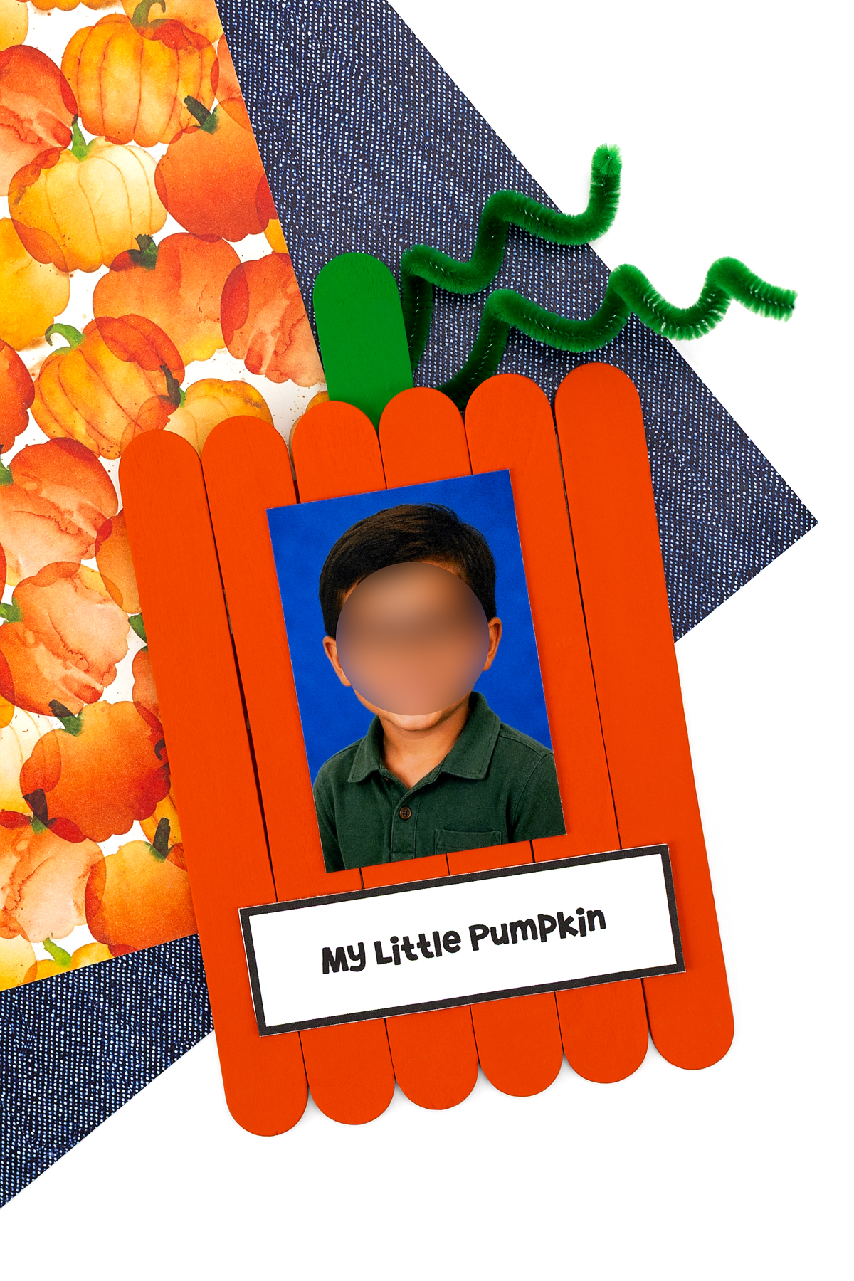 Finished popsicle stick pumpkin keepsake craft with photo, stem, and curly vine.