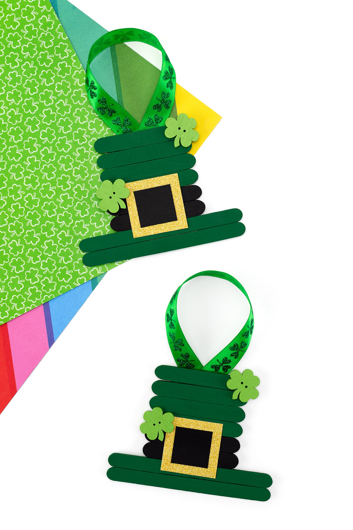 A small leprechaun hat assembled from popsicle sticks and decorated with green and orange paper.