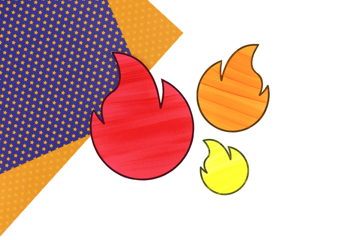 Red, orange, and yellow paper flames cut from the printable template, arranged on a table.