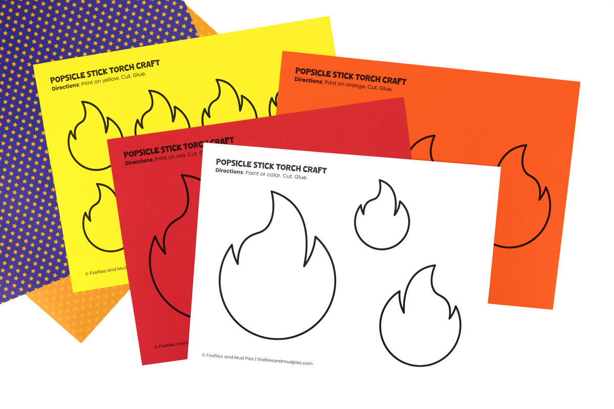 Printed Olympic torch flame template on white cardstock with scissors nearby, ready to cut.