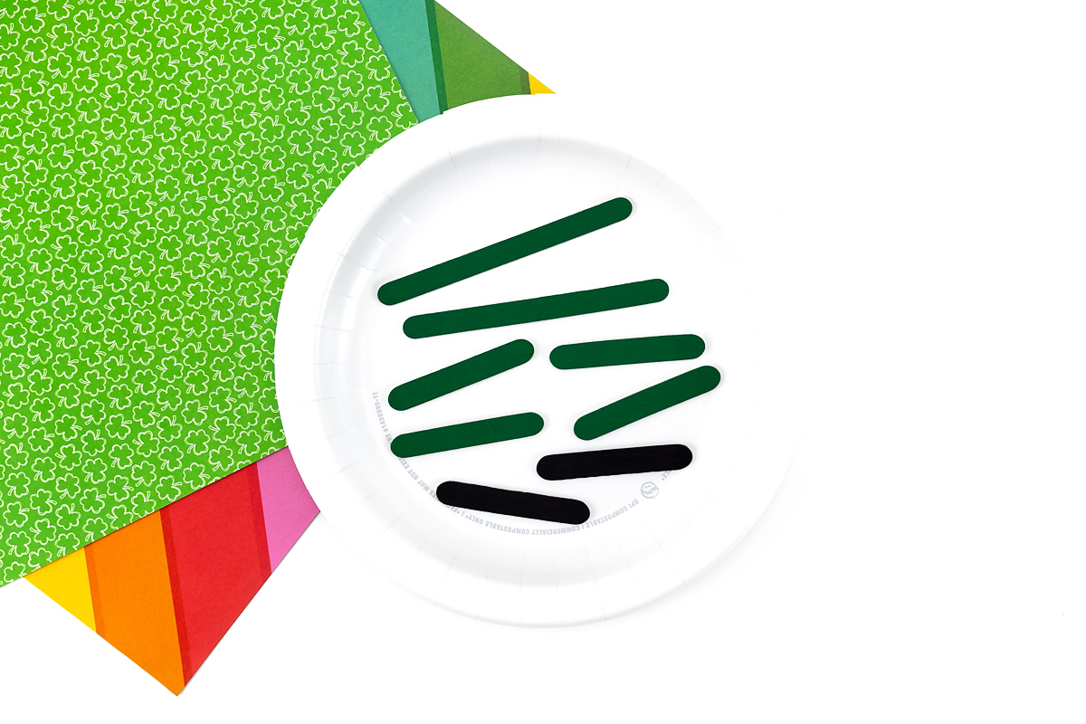 Painted popsicle sticks on a plate. 