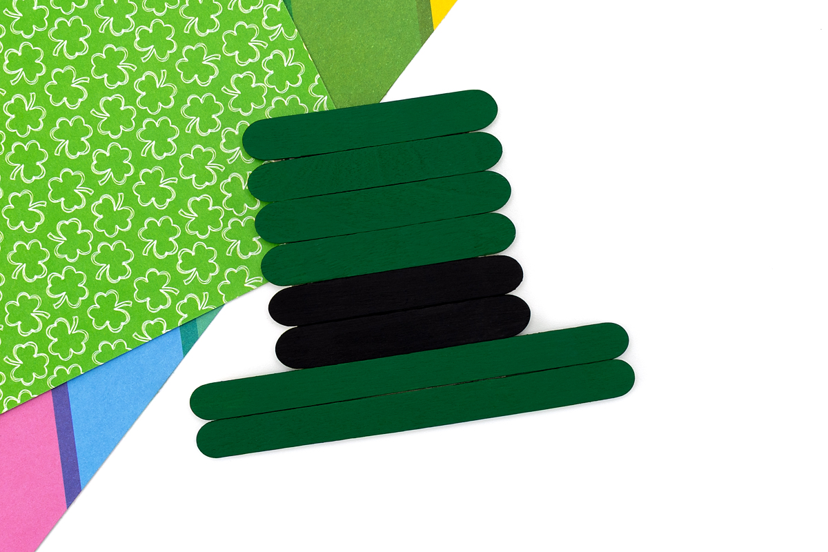 Painted popsicle sticks stacked into a hat shape. 