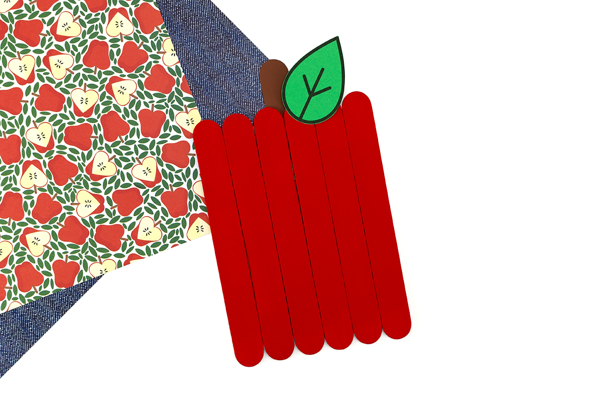 Red painted popsicle sticks glued together with a brown craft stick stem and green felt leaf, before the photo is added.