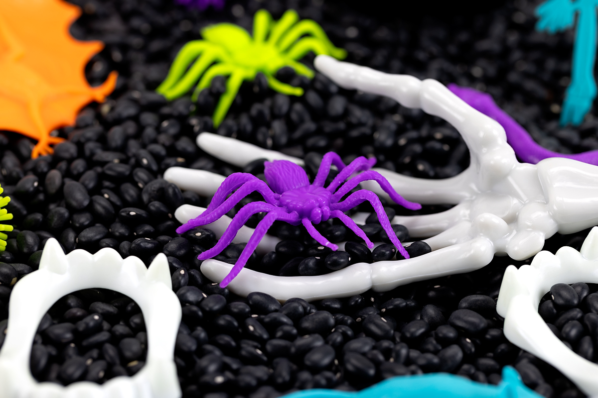 Purple spider inside of skeleton salad tongs.