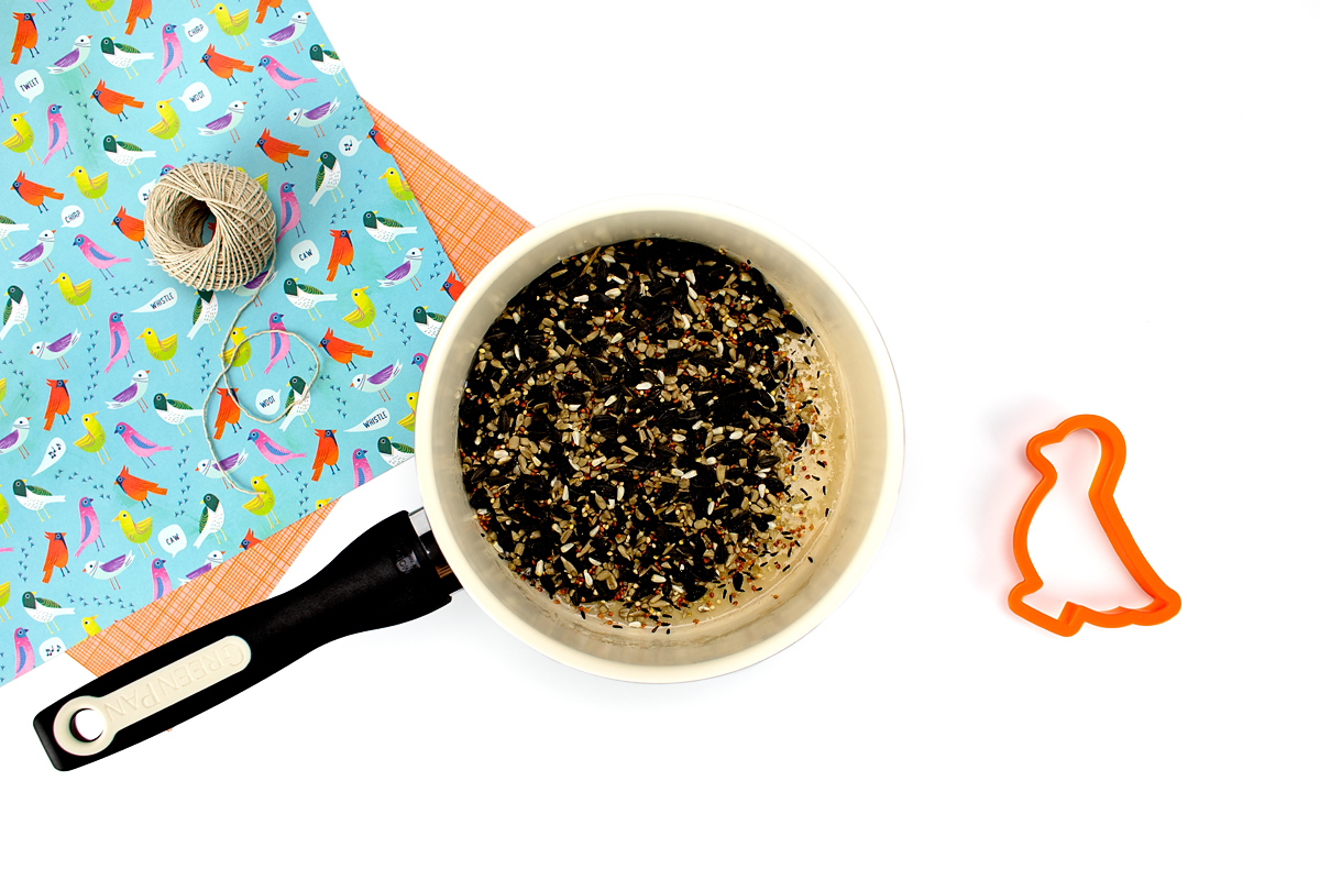 Stirring birdseed into the agar agar solution to make birdseed ornaments.