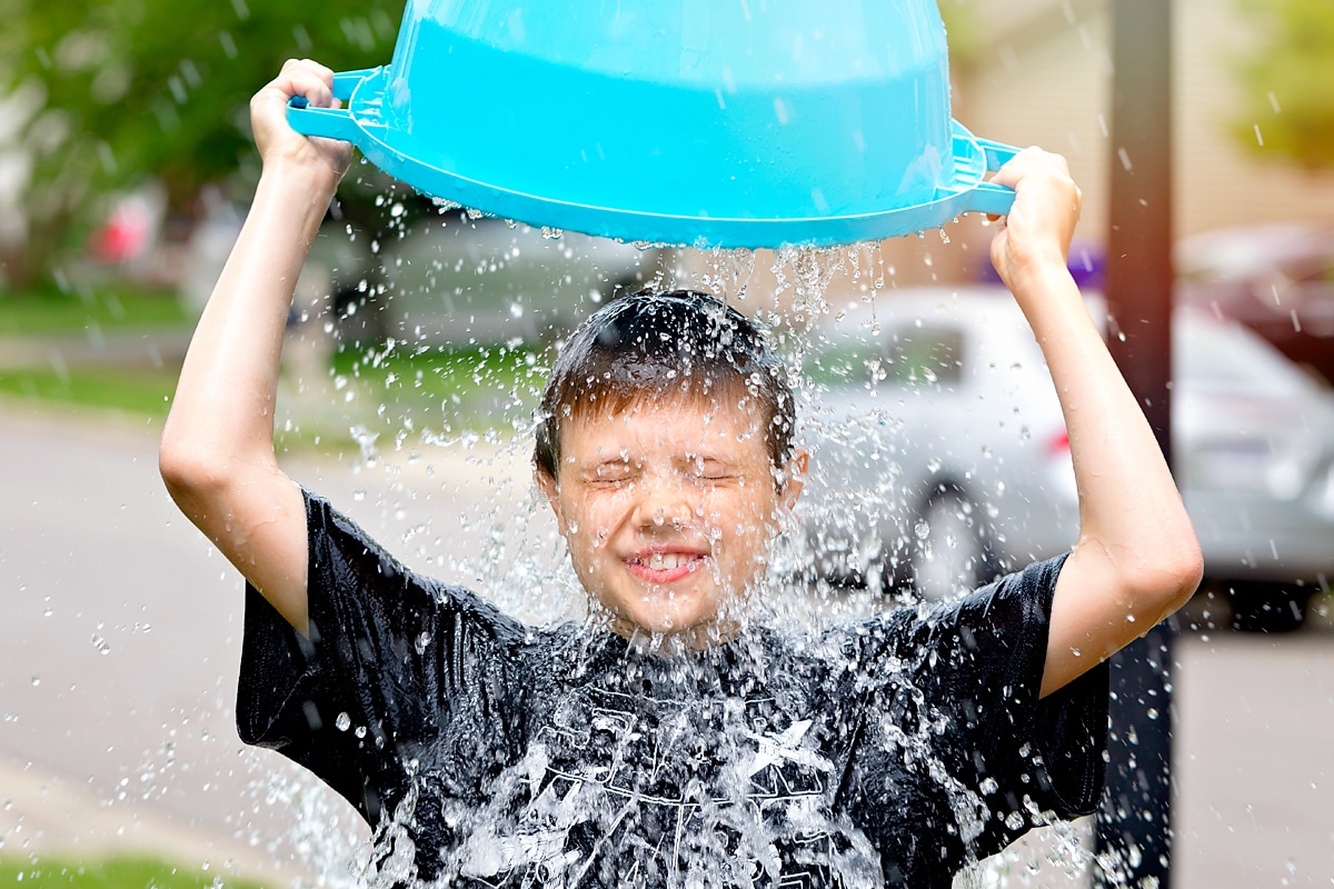 Child pouring water over his head.