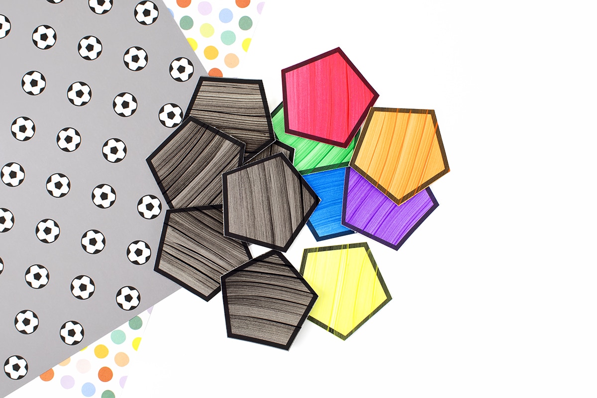 Painted pentagons cut out to make a soccer ball craft.