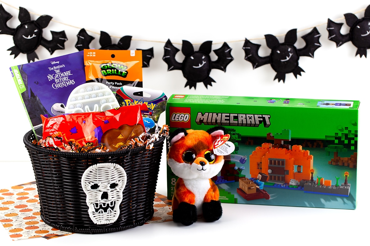 A Halloween Boo Basket for kids filled with toys, candy, books, LEGOs, and a stuffed fox.