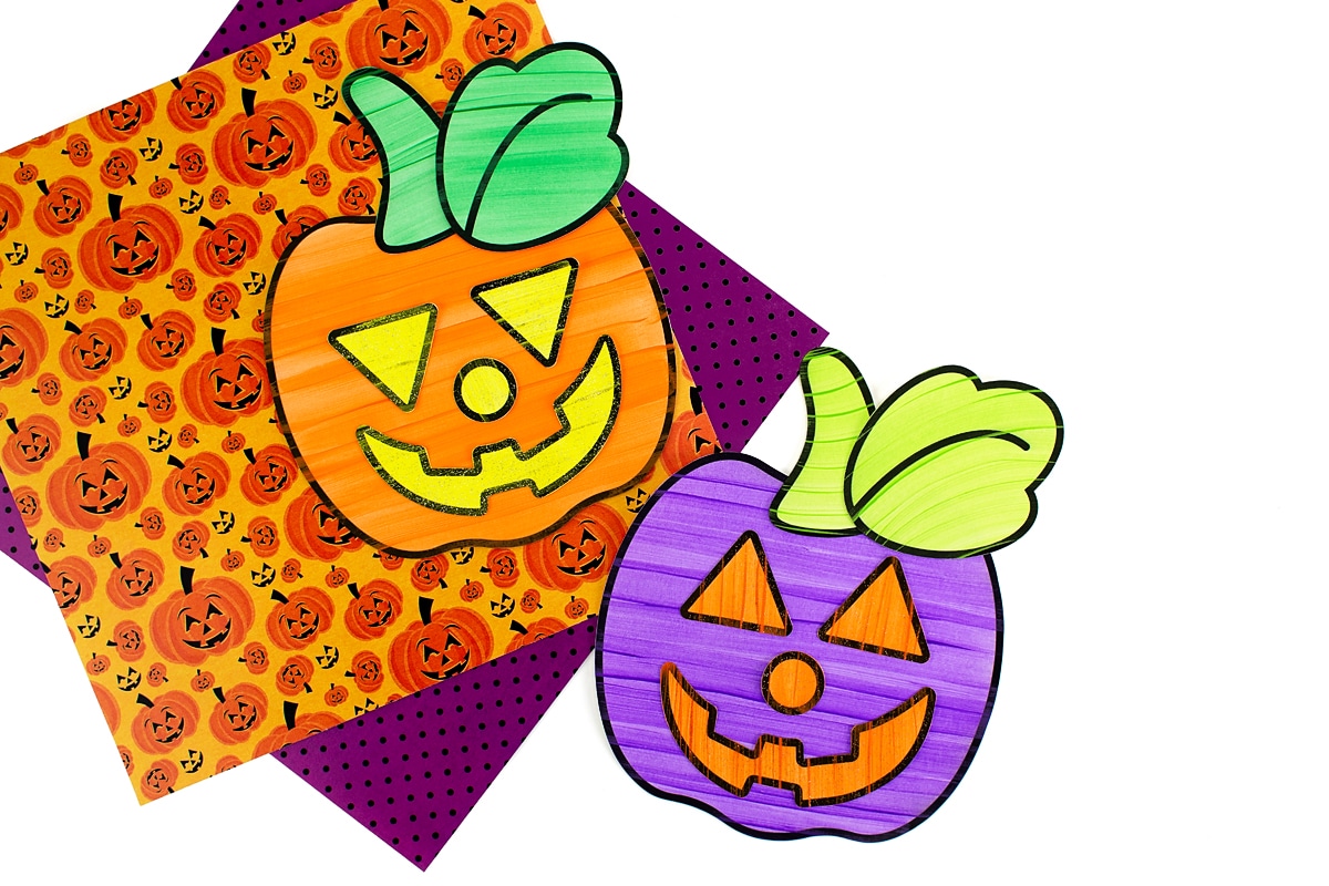Orange and purple jack-o'-lanterns on top of orange and purple scrapbook paper.