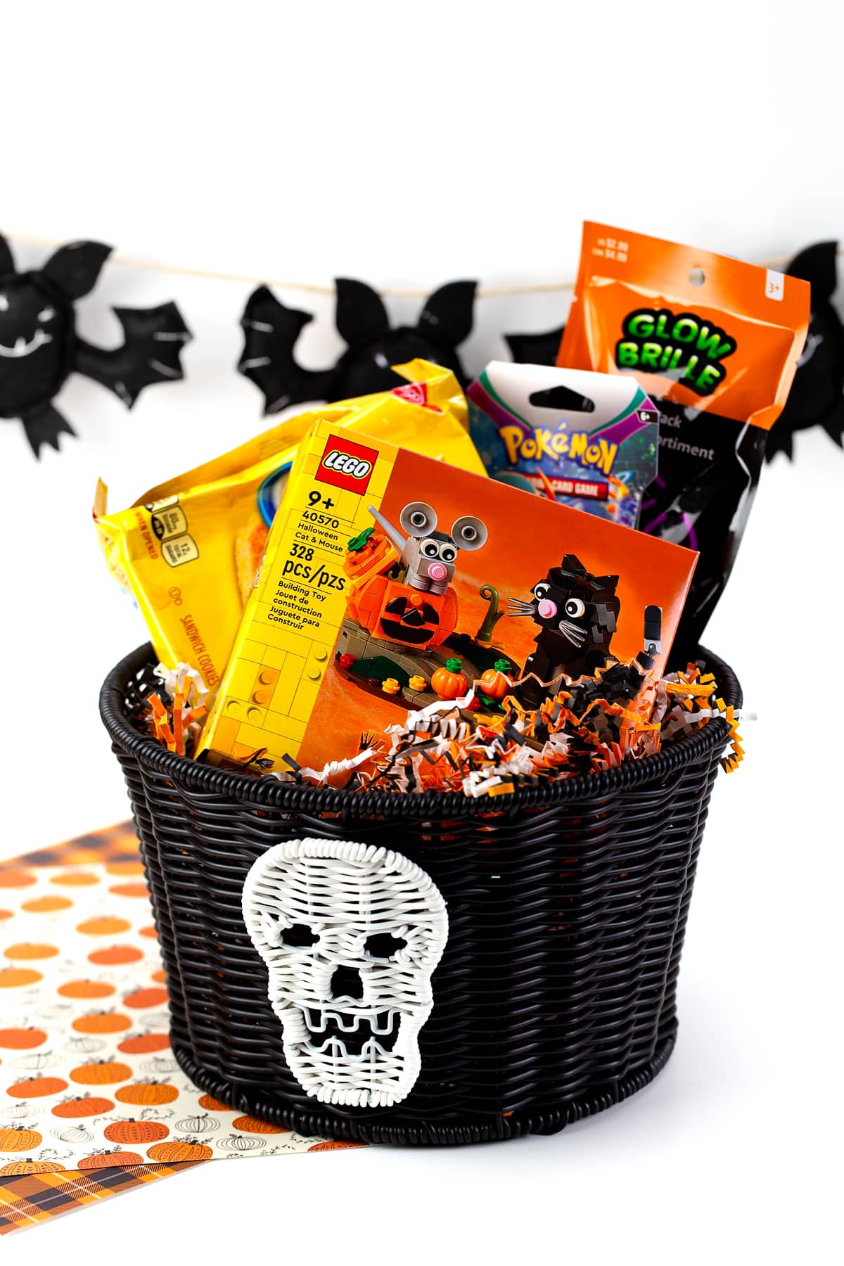 A Halloween Boo Basket filled with LEGOs, Pokemon Cards, cookies, and glow sticks.