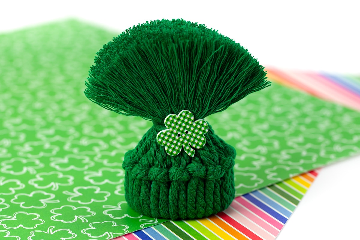 Miniature yarn and toilet paper roll hat.