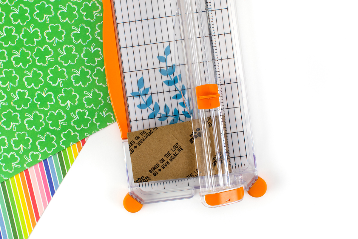 Cutting a toilet paper roll with a paper cutter.