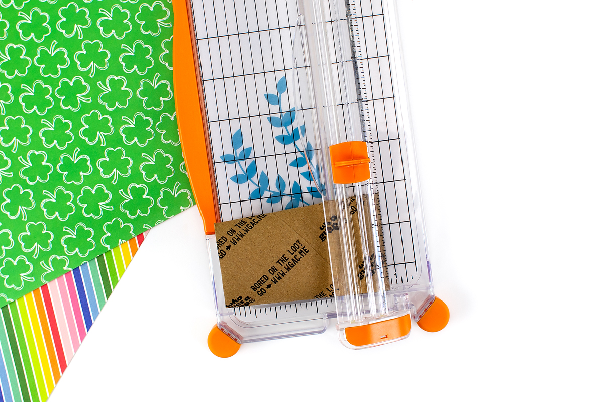 Using a paper cutter to cut a toilet paper roll for Macrame Gnomes. 