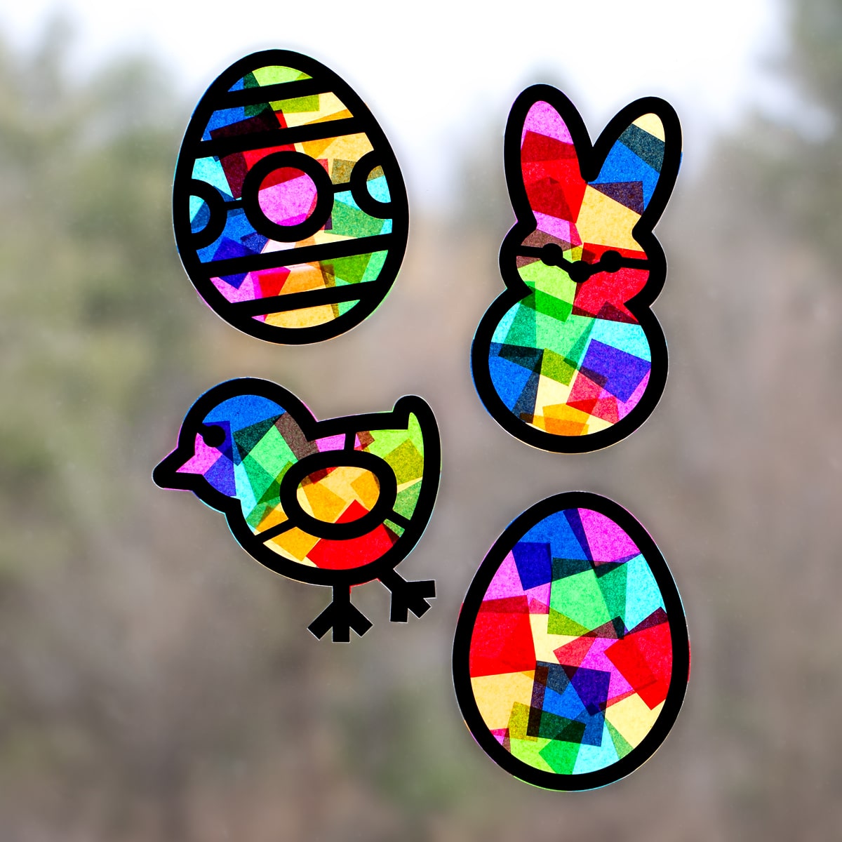 Four Easter suncatchers displayed in a sunny window.