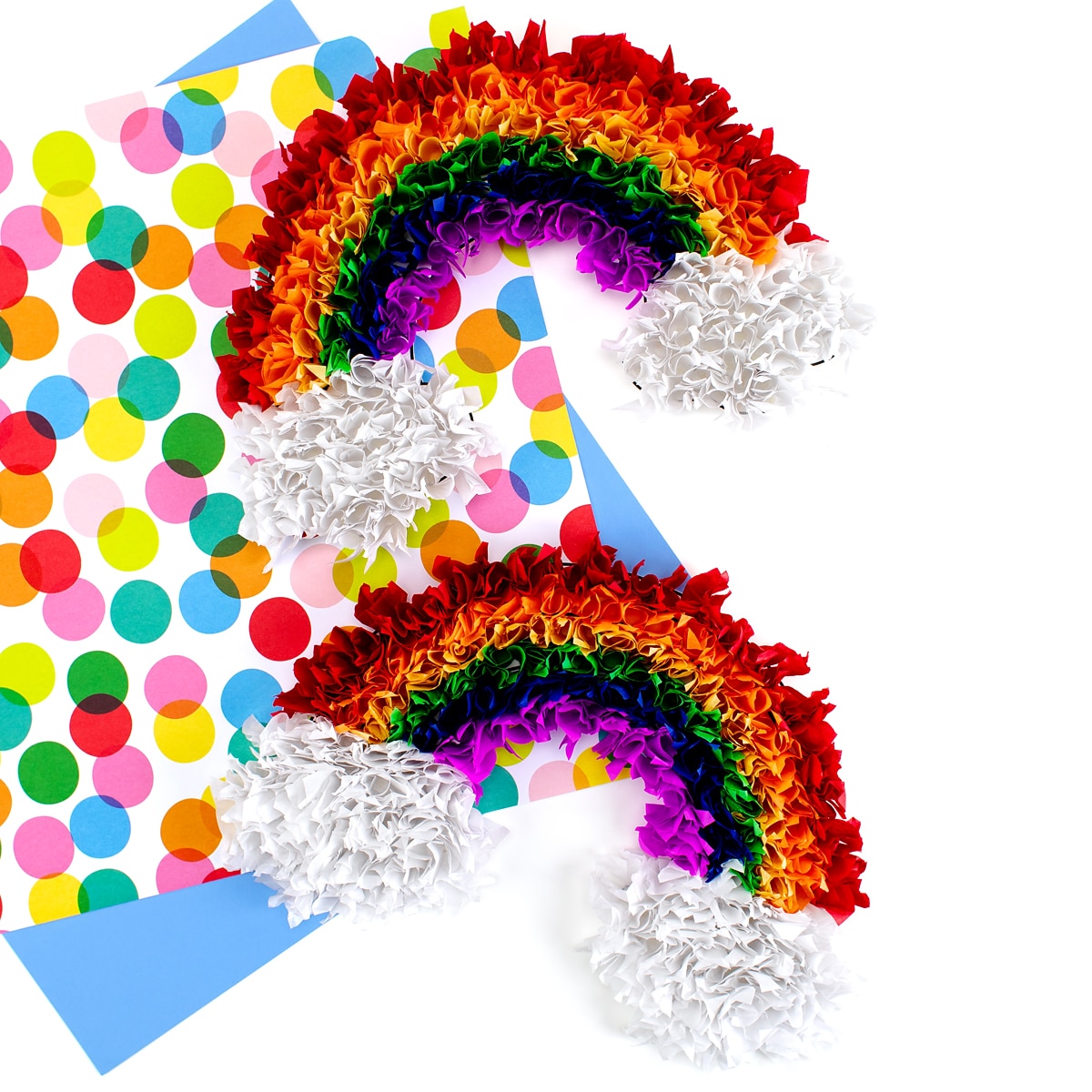 Two tissue paper rainbows on colorful scrapbook paper.