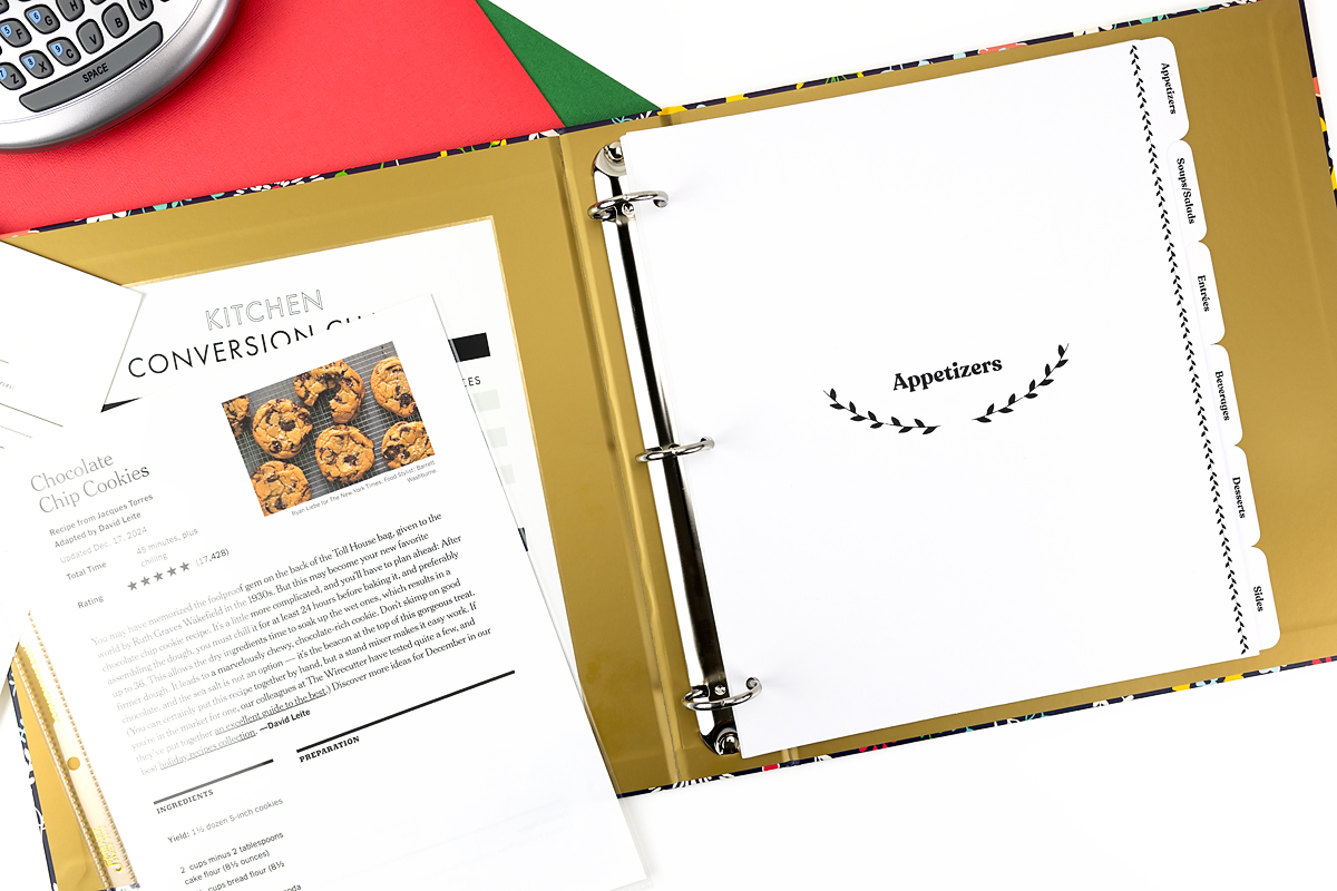 Open recipe binder and chocolate chip cookie recipe on a table.