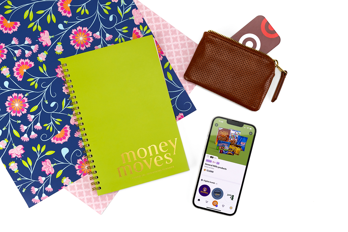 Money Moves book on table, paired with a wallet, gift card, and phone with the Fetch app open.