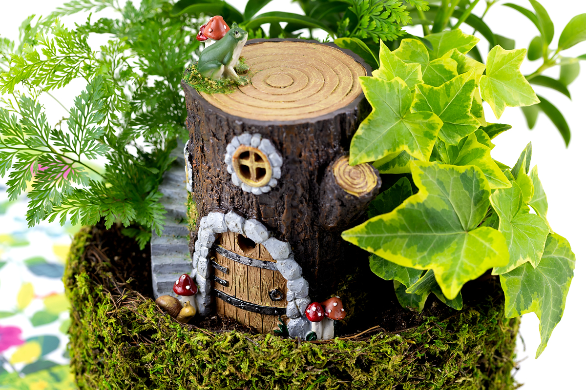 Log house in a basket of plants.