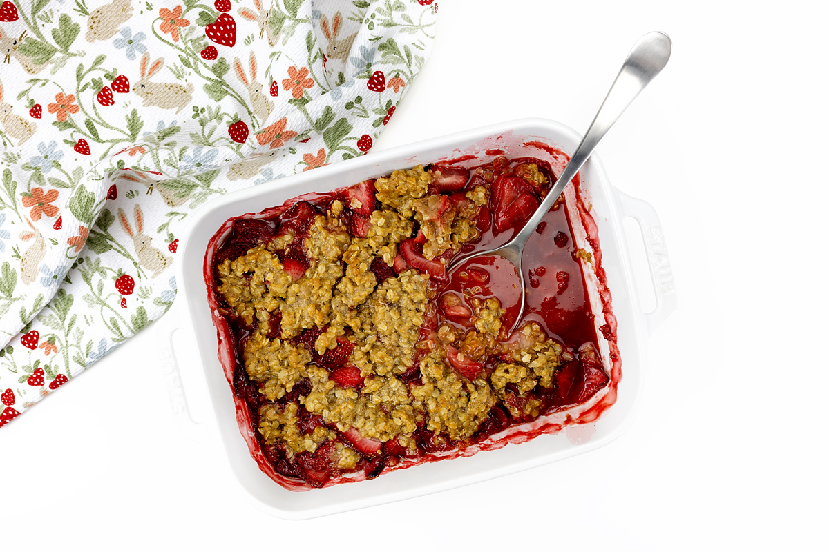 Strawberry crisp with a spoon.