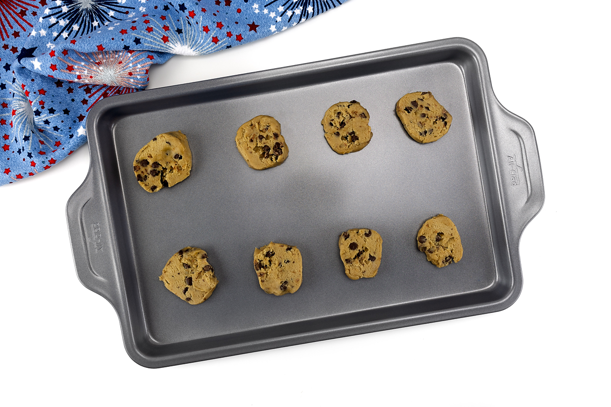 Chocolate chip cookie dough on a baking sheet.