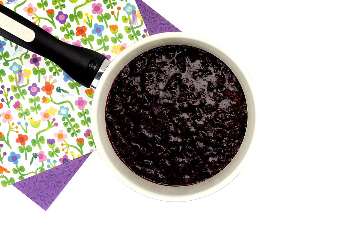 Cooked blackcurrants in a pot.