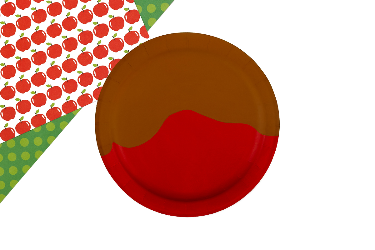 Caramel topped red paper plate apple.