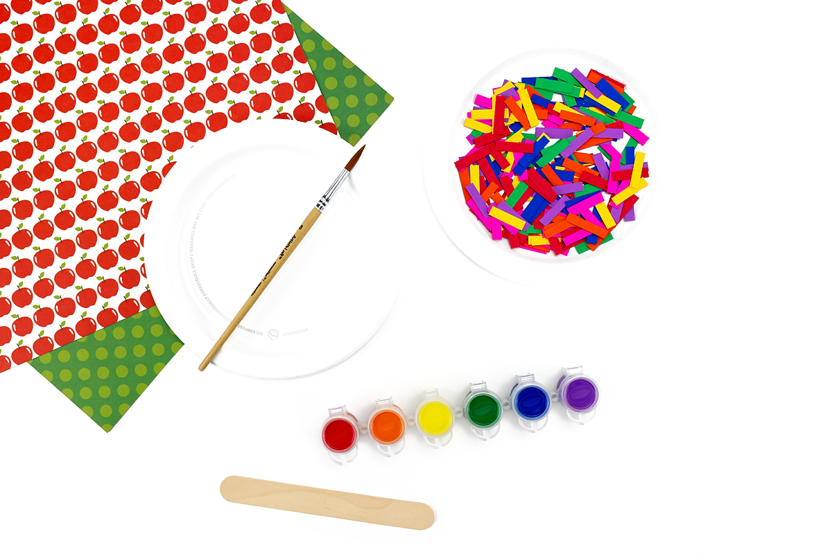 Supplies needed to make paper plate apples.