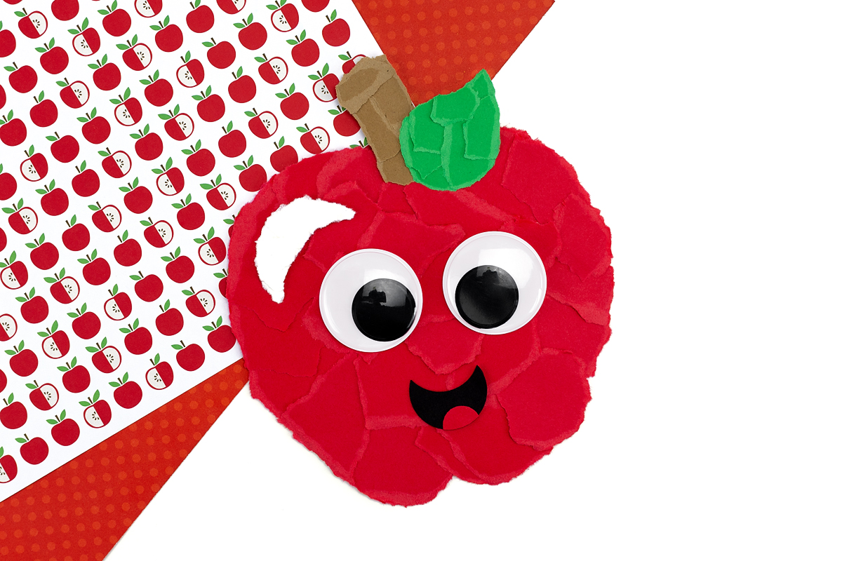 Finished torn paper apple with wiggly eyes and a mouth.