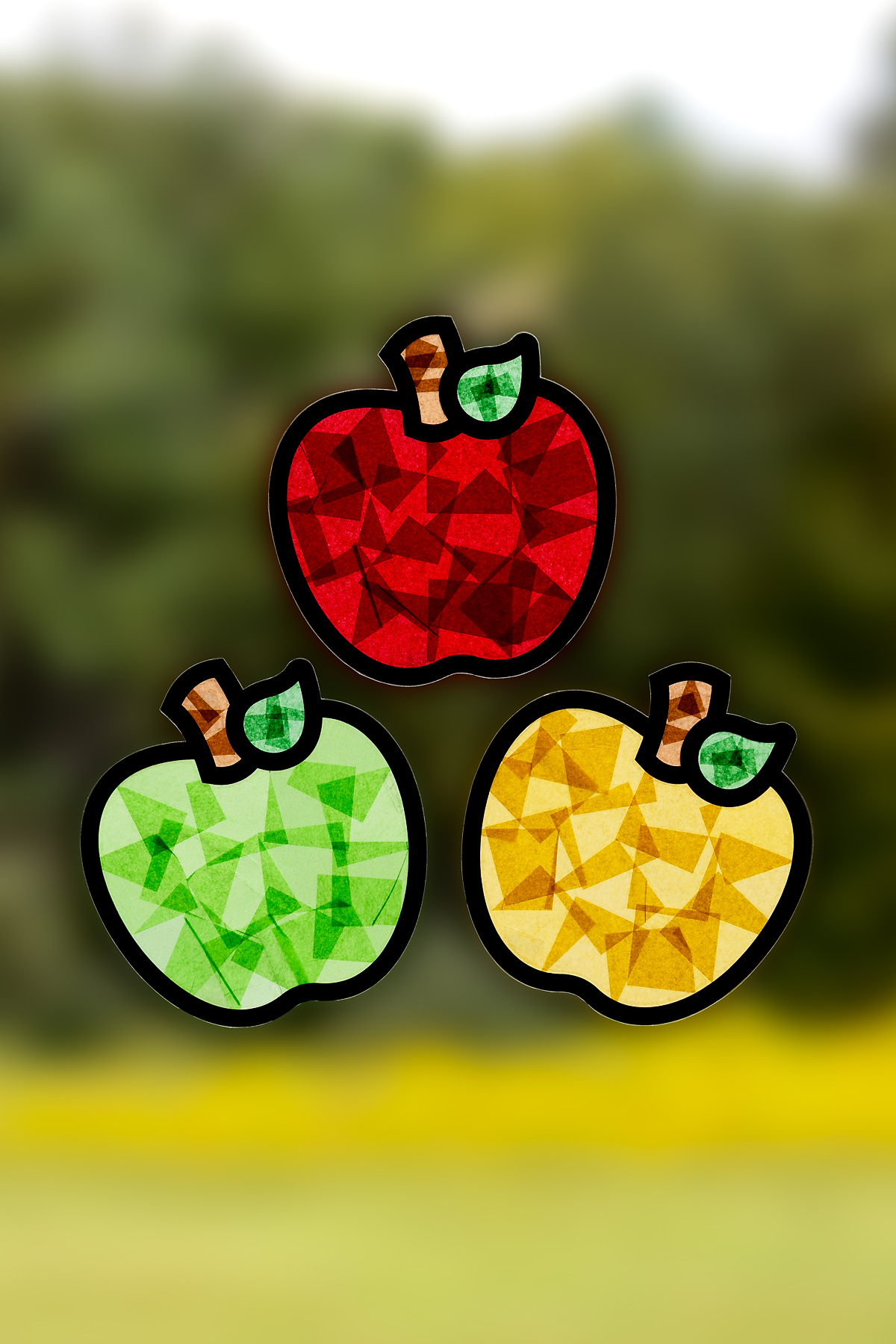 Finished apple suncatchers hanging on a window.