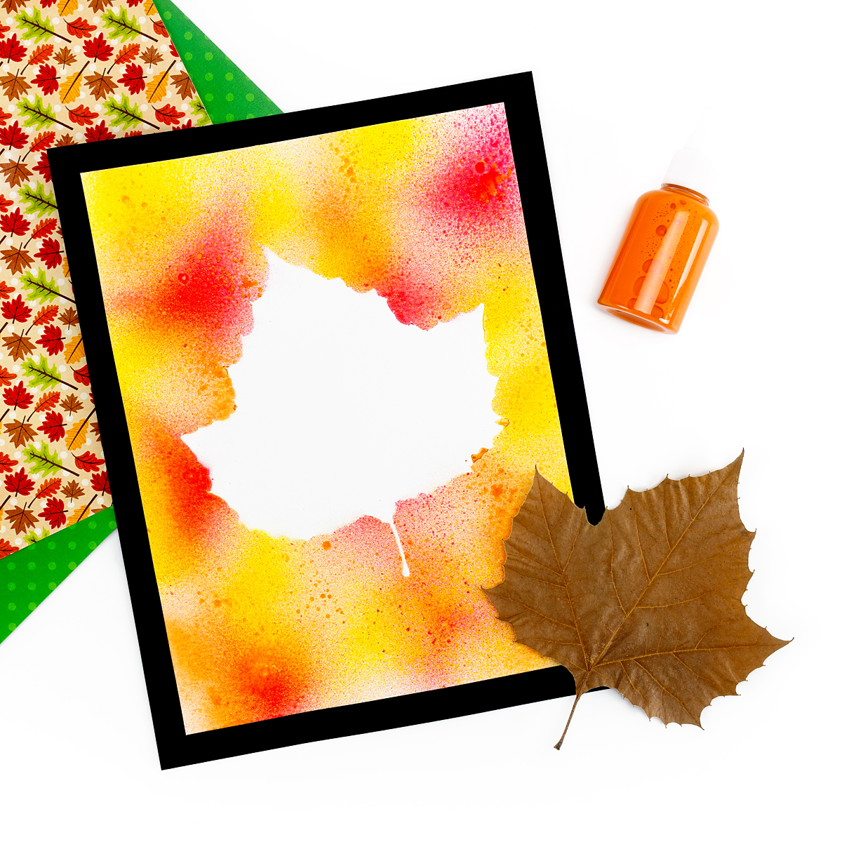 Photo of finished artwork with spray bottle and leaf.