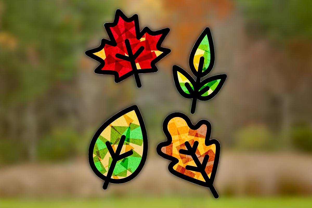 Finished fall leaf suncatchers hanging on a window.