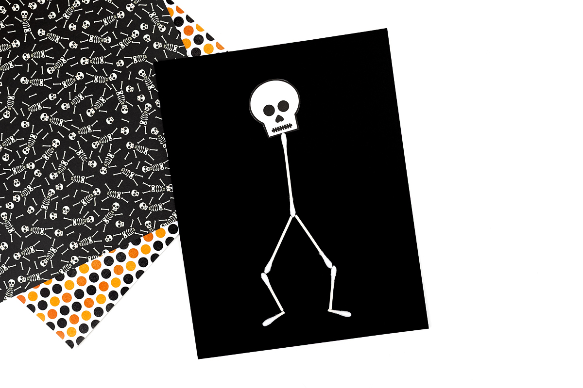 Skeleton head and cotton swabs glued down on paper.