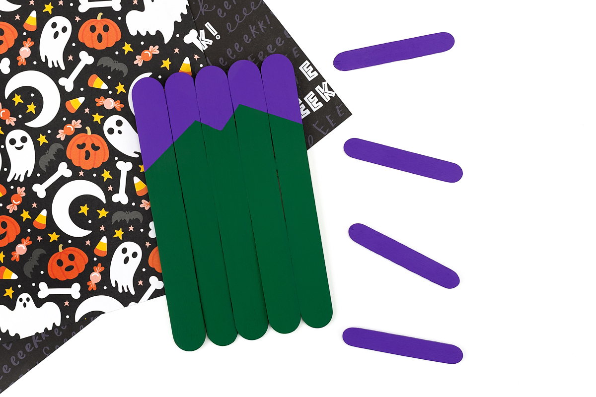 Green and purple painted popsicle sticks.
