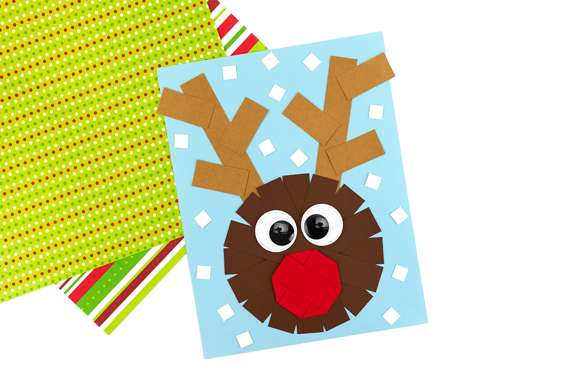 Gluing small white squares around the reindeer’s face and antlers to look like falling snow.
