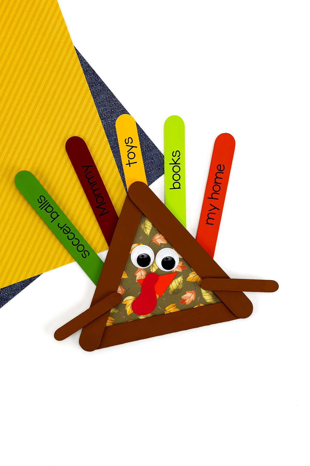 Finished popsicle stick turkey craft with thankful words.