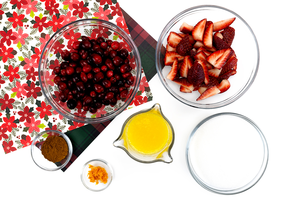 Ingredients prepared for making Christmas Jam, including berries, sugar, orange juice, and spices.