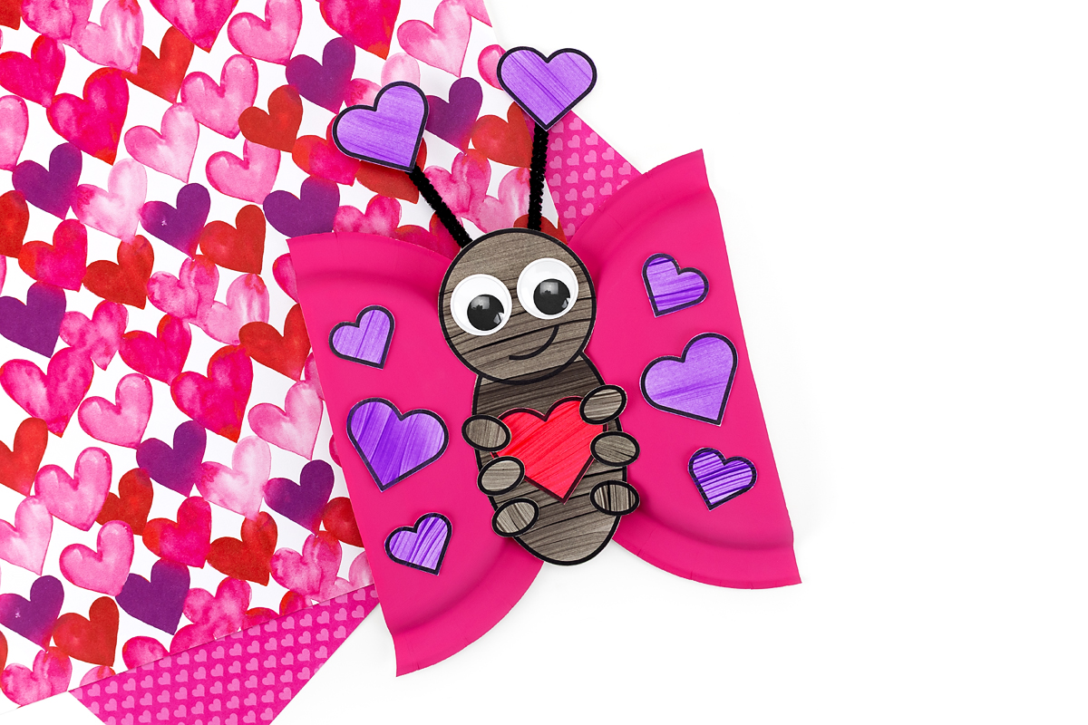A close-up view of a love bug craft with googly eyes and pipe cleaner antennae.