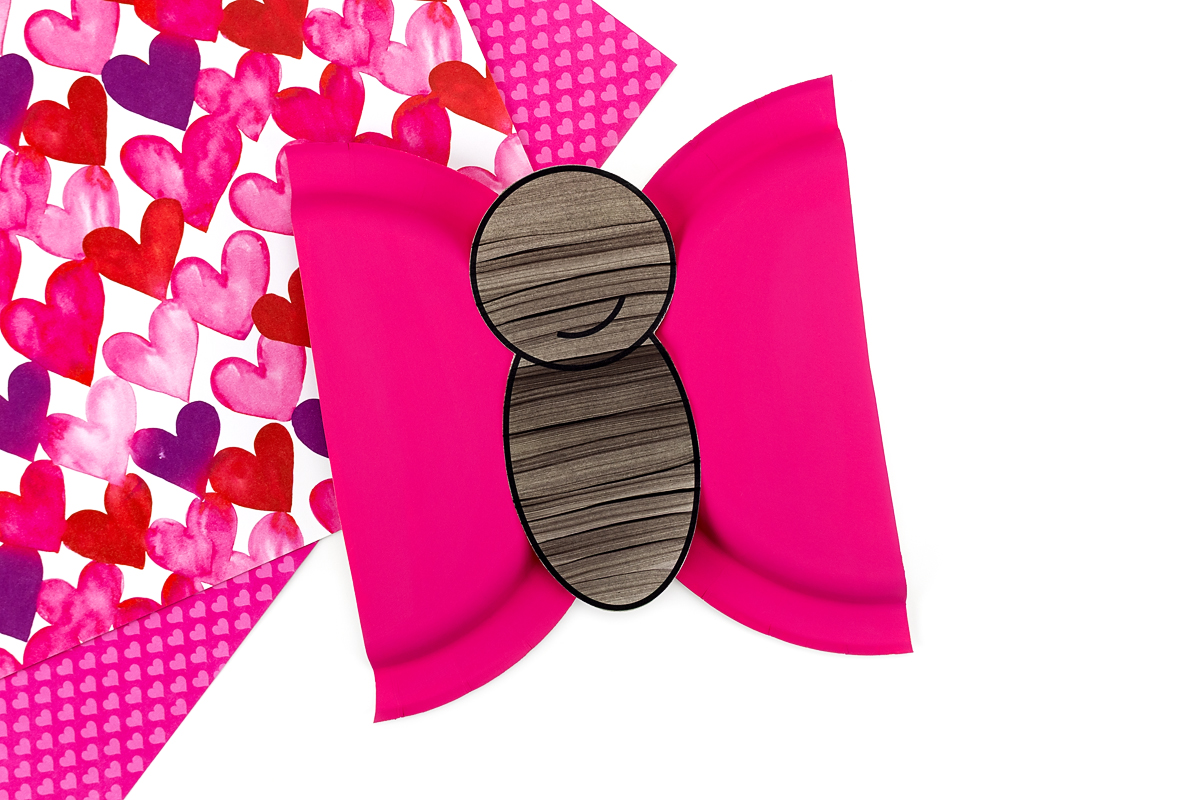 The love bug body being glued onto paper plate wings during assembly.