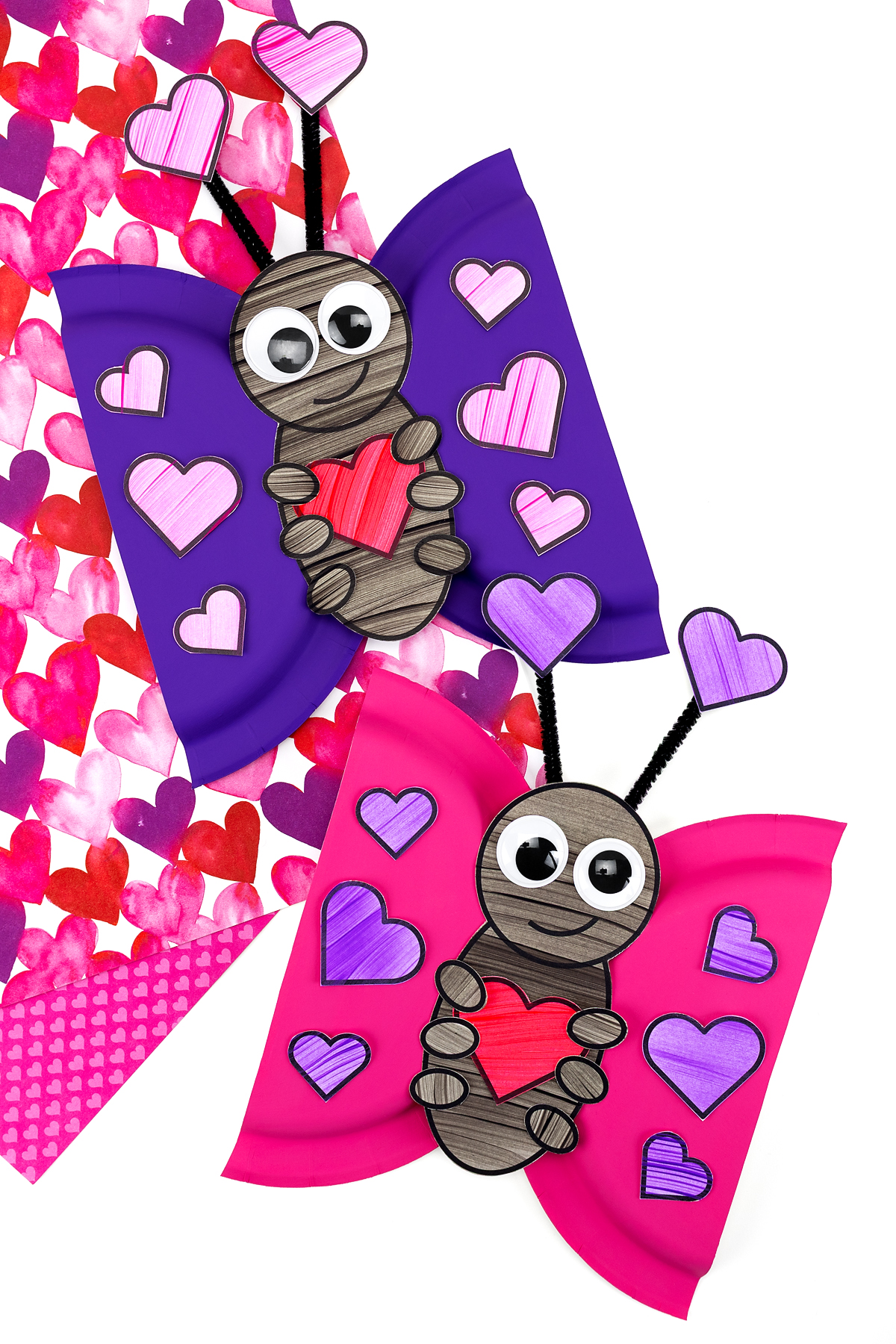 Love bug paper plate crafts displayed together on a classroom table. 