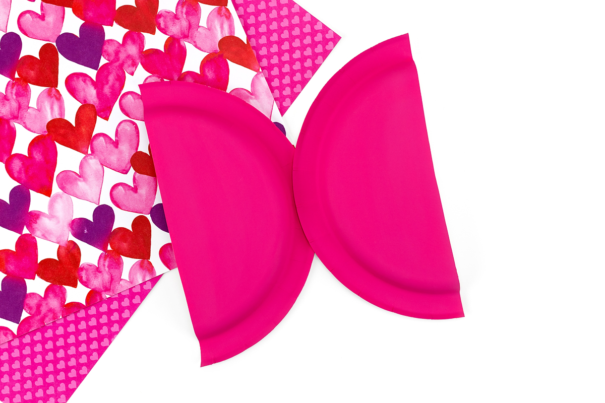 A paper plate cut in half and glued together to form wings for a love bug craft.