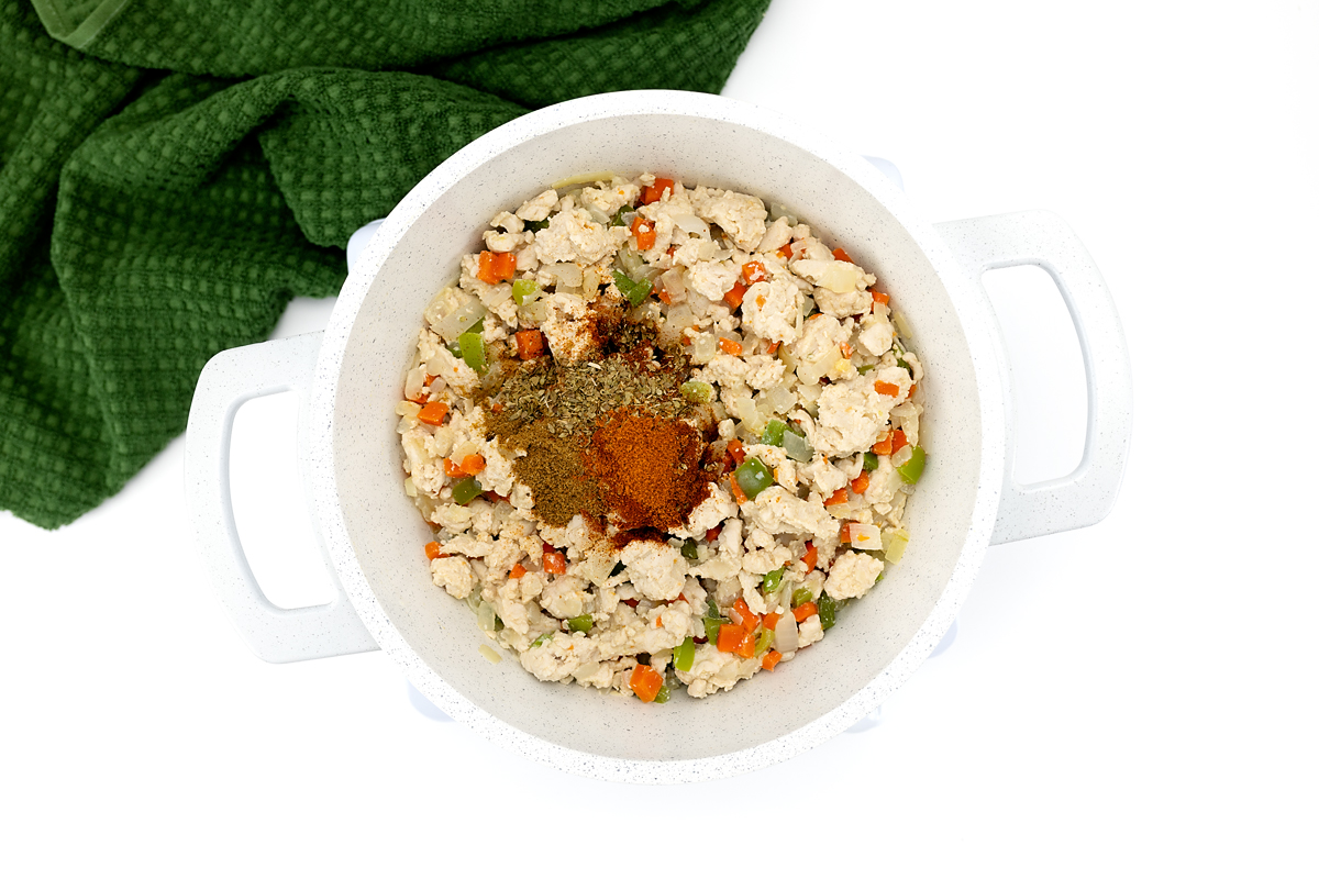 Chili spices being stirred into the turkey and vegetable mixture.