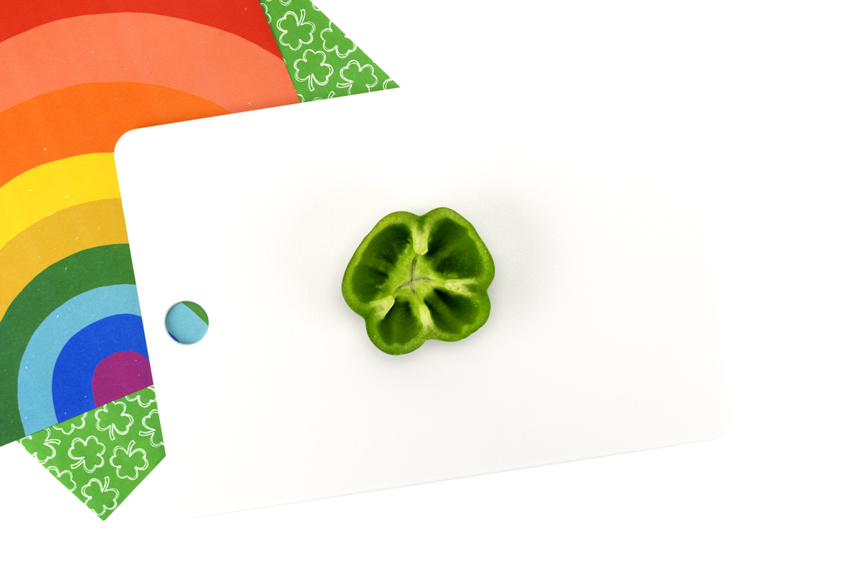Top view of a green bell pepper cut horizontally to reveal a natural shamrock shape inside.