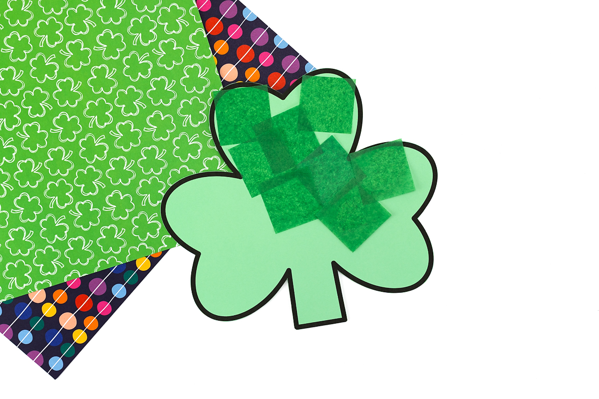 Green tissue paper squares being added to a shamrock craft for fine motor practice.