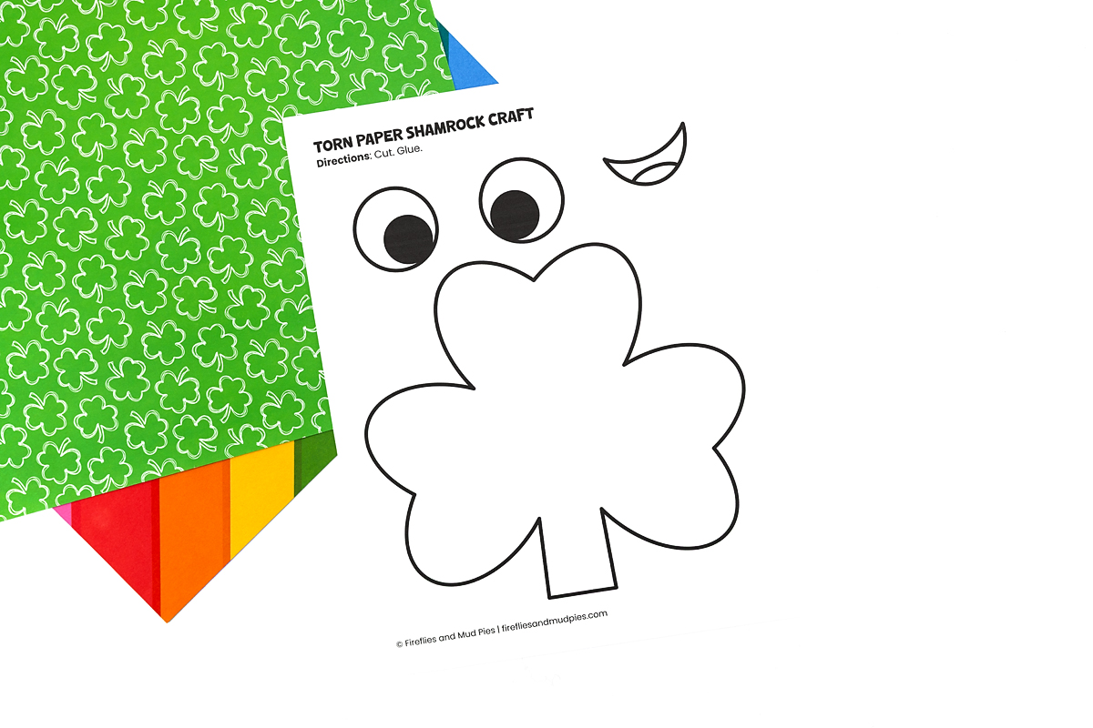 Free printable shamrock template printed on white paper with bold cutting lines for kids.